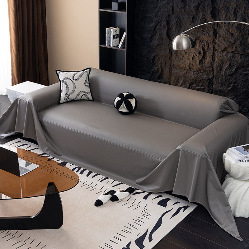 Sofaüberwurf aus Kunstleder Zinngrau, über ein Sofa gelegt